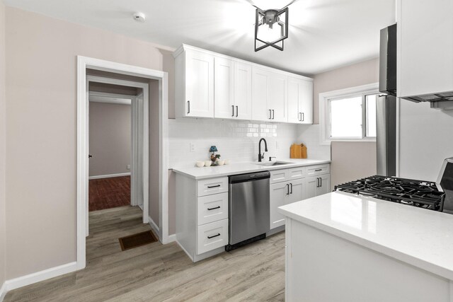 kitchen with dishwasher, sink, light hardwood / wood-style flooring, and white cabinets