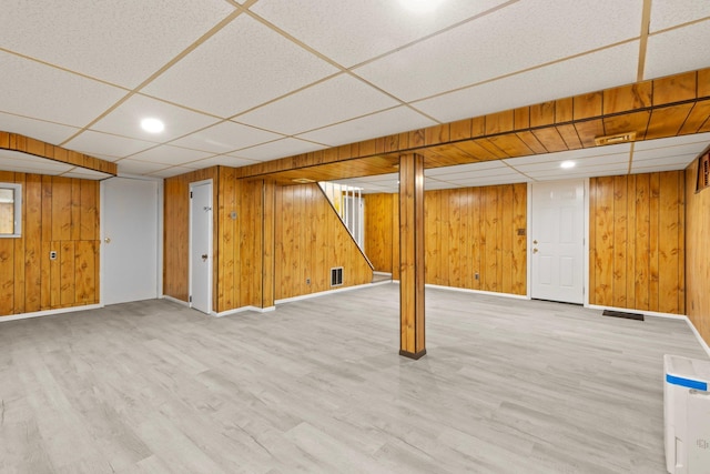 basement with wood-type flooring and wood walls