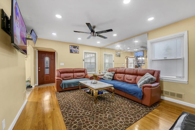 living room featuring wood-type flooring and ceiling fan