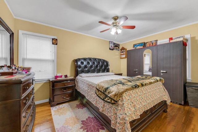 bedroom with ceiling fan, crown molding, and light hardwood / wood-style flooring