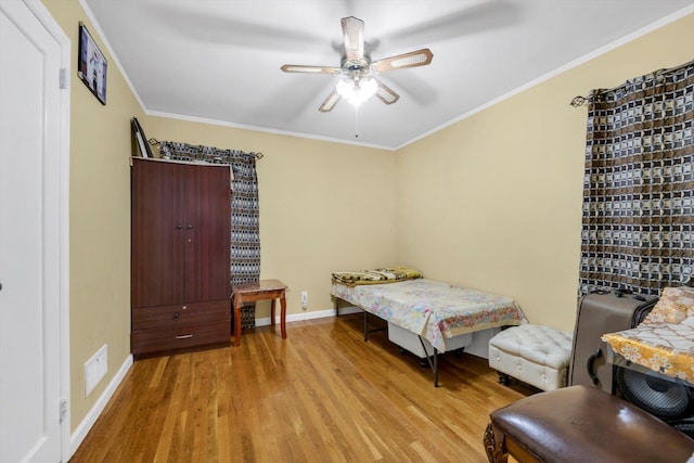 bedroom featuring ceiling fan, crown molding, and light hardwood / wood-style flooring