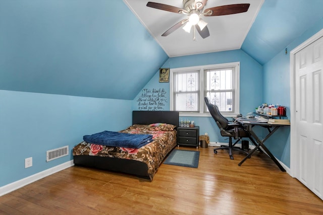 bedroom with ceiling fan, hardwood / wood-style floors, and vaulted ceiling