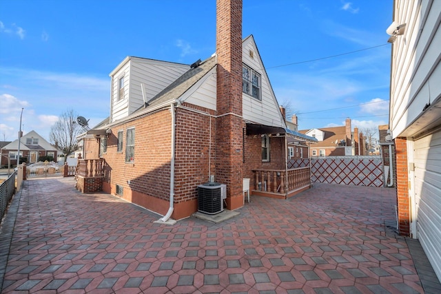 view of side of property with a patio and central AC unit