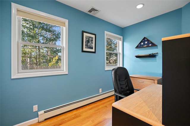 office space featuring baseboard heating and wood-type flooring