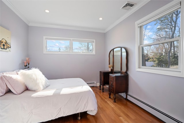 bedroom featuring a baseboard heating unit, ornamental molding, and hardwood / wood-style floors