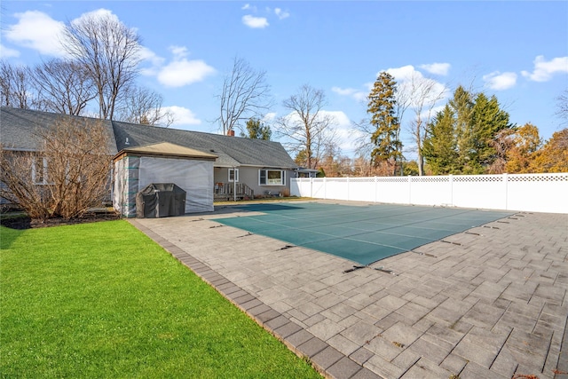 view of swimming pool with a patio area and a yard