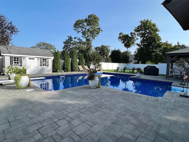 view of pool with an outbuilding, a gazebo, a patio, and area for grilling