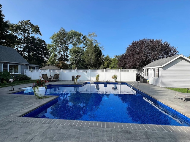 view of pool with an outbuilding and a patio