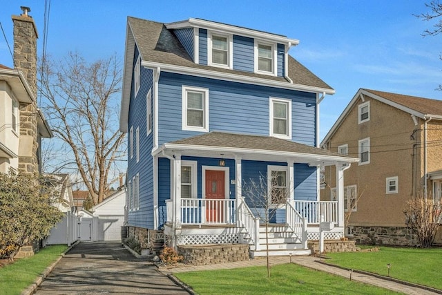 view of front of home featuring an outbuilding, a garage, and a front lawn