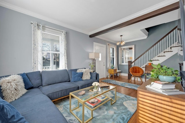 living room with crown molding, wood-type flooring, and a chandelier