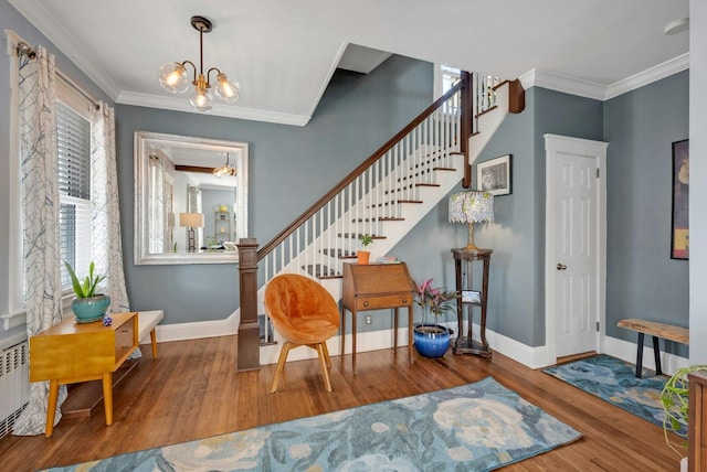 foyer entrance featuring a notable chandelier, hardwood / wood-style flooring, and ornamental molding