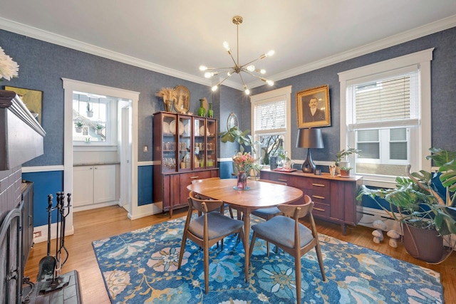 dining area with crown molding, an inviting chandelier, and light hardwood / wood-style floors