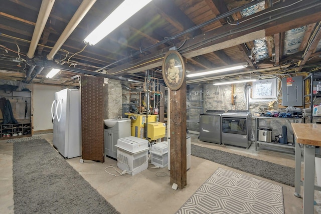 basement with fridge, sink, electric panel, and washer and clothes dryer