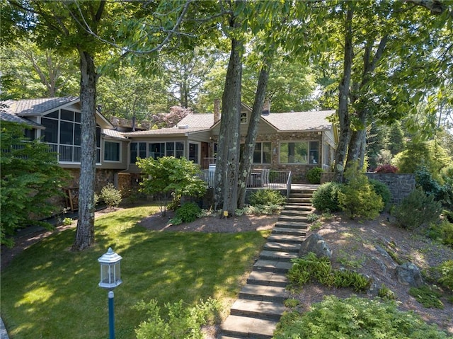 view of front of property featuring a sunroom and a front lawn