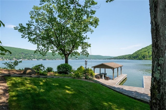 dock area featuring a gazebo, a yard, and a water and mountain view