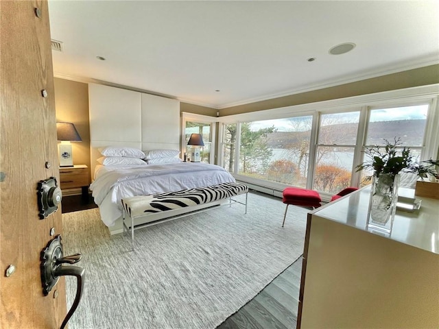 bedroom with crown molding and hardwood / wood-style floors