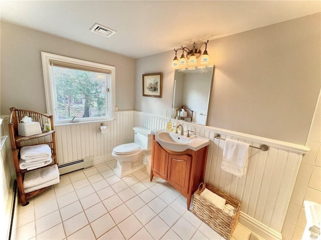 bathroom with tile patterned flooring, vanity, toilet, and a baseboard heating unit