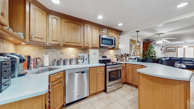 kitchen with sink, ceiling fan, decorative light fixtures, kitchen peninsula, and stainless steel appliances