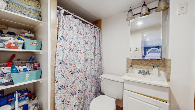 bathroom featuring decorative backsplash, toilet, and vanity