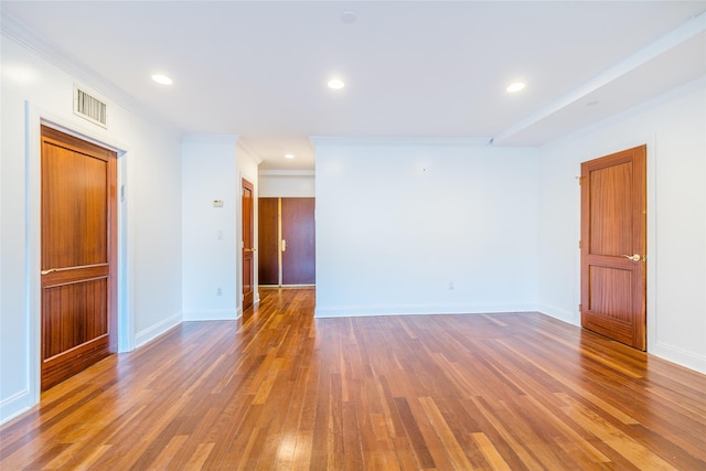 empty room with crown molding and hardwood / wood-style flooring