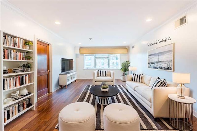 living room with built in shelves, dark hardwood / wood-style floors, and crown molding