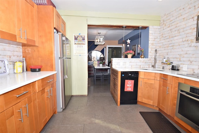 kitchen with sink, tasteful backsplash, decorative light fixtures, black appliances, and dark tile patterned flooring