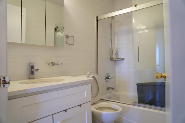 full bathroom featuring toilet, combined bath / shower with glass door, backsplash, and vanity