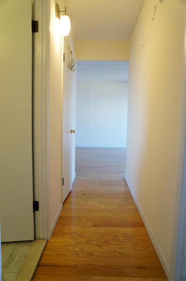 corridor with light hardwood / wood-style floors