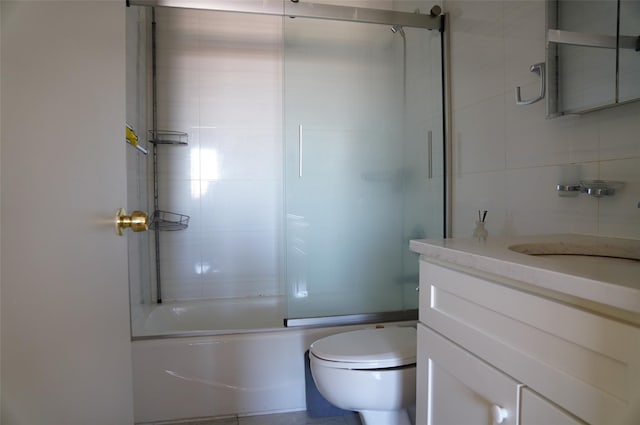 full bathroom featuring vanity, toilet, and combined bath / shower with glass door