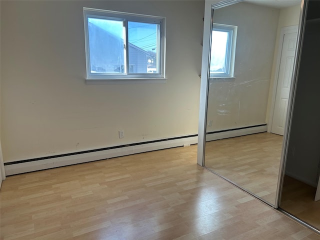 unfurnished bedroom with light wood-type flooring and a baseboard radiator