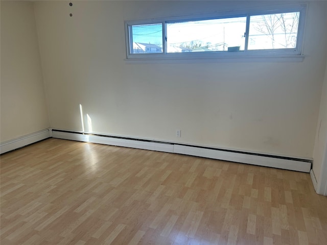 spare room featuring light wood-type flooring and baseboard heating