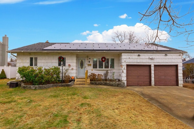 ranch-style house featuring solar panels, a front yard, and a garage