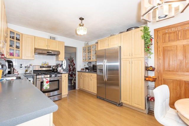 kitchen with light hardwood / wood-style floors, stainless steel appliances, sink, decorative light fixtures, and tasteful backsplash