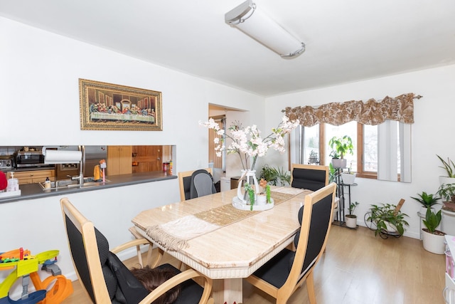 dining space featuring sink and light wood-type flooring