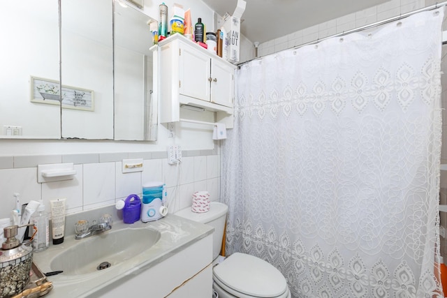 bathroom featuring tile walls, toilet, and vanity