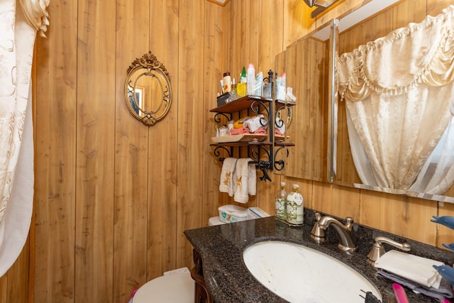 bathroom featuring sink and wooden walls