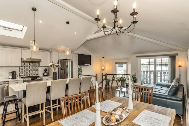 dining space featuring an inviting chandelier, lofted ceiling with skylight, and light hardwood / wood-style flooring