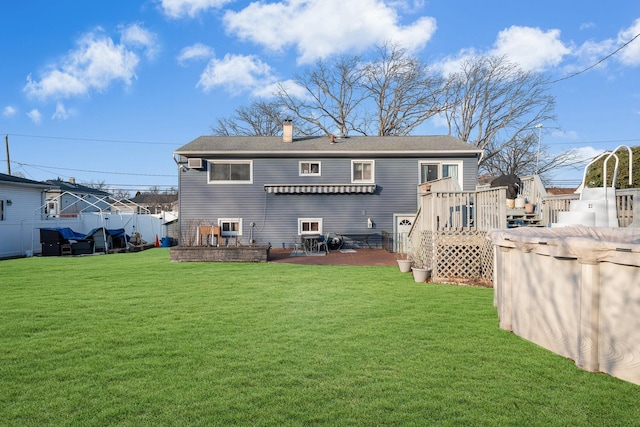 rear view of property with a lawn, a patio area, and a swimming pool