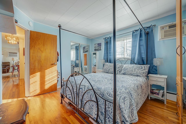 bedroom featuring a closet, hardwood / wood-style floors, and an AC wall unit