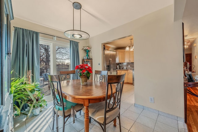 tiled dining room featuring an inviting chandelier