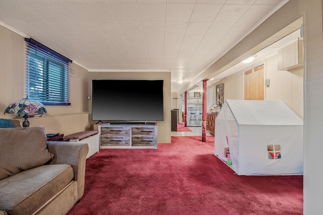 living room with ornamental molding, carpet, and wooden walls