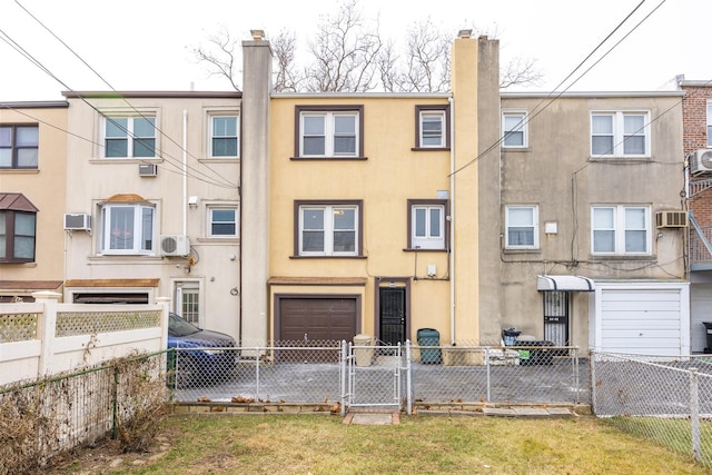 rear view of house featuring a garage and a wall unit AC