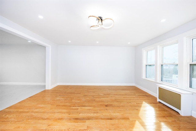 empty room featuring radiator and light hardwood / wood-style floors