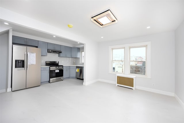 kitchen featuring appliances with stainless steel finishes, tasteful backsplash, and radiator heating unit