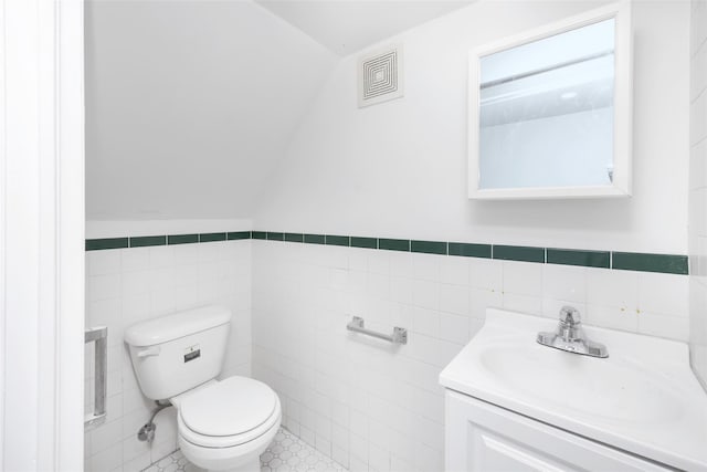 bathroom featuring tile walls, toilet, and vanity