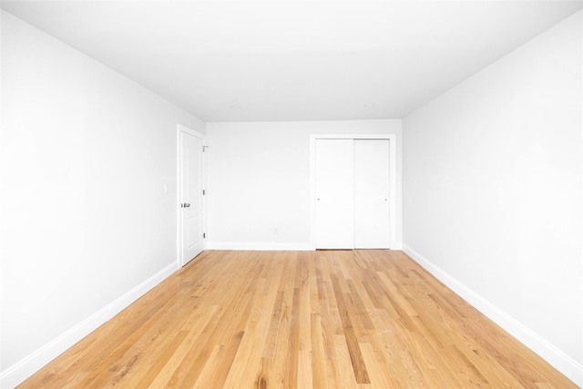 unfurnished bedroom featuring a closet and light wood-type flooring