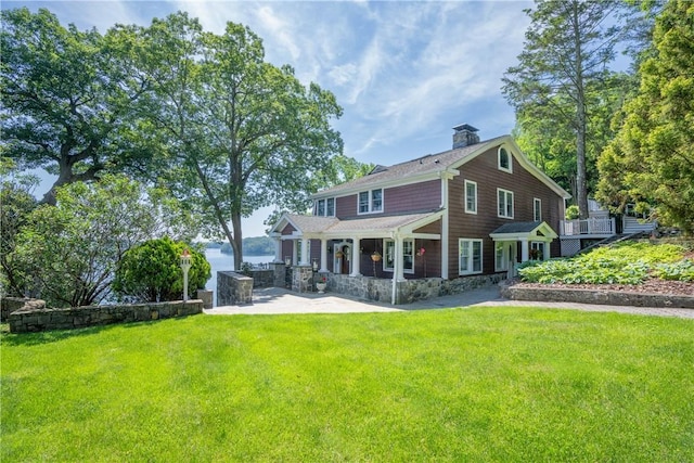 rear view of house with a patio area and a lawn