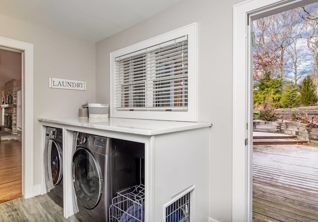 laundry area with wood-type flooring and separate washer and dryer