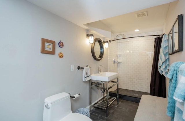 bathroom featuring a shower with curtain, sink, tile patterned flooring, and toilet