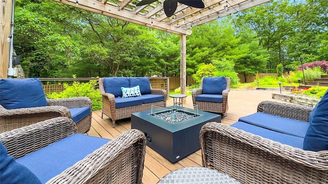 wooden deck featuring an outdoor living space with a fire pit, ceiling fan, and a pergola